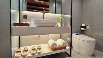 Un baño moderno con lavamanos doble, inodoro, estante con zapatillas y espejo.