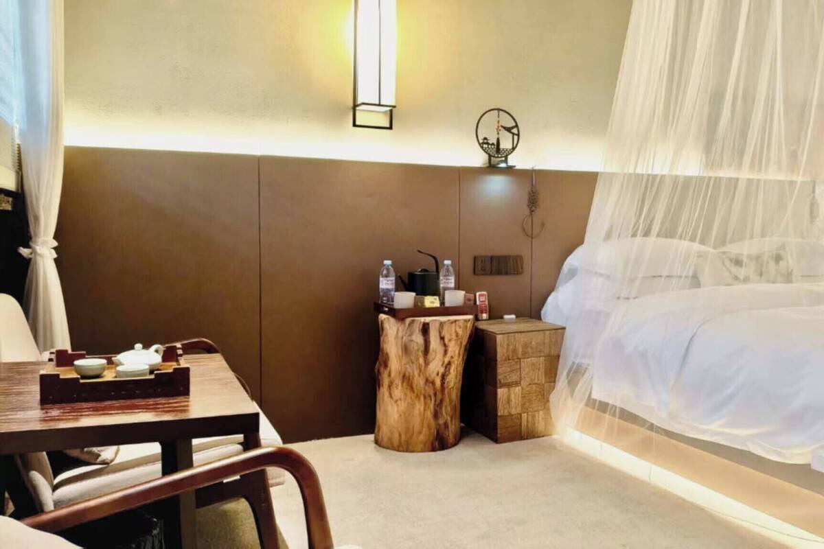 A bedroom with a bed, bedside table, and a chair.