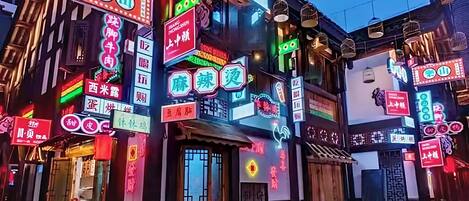 A building with multiple illuminated signs, indicating various businesses.
