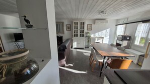 Ein modernes Interieur mit Essbereich, Küche und einem großen Fenster.