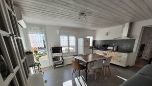 Eine moderne Küche mit Essbereich, einem eingebauten Backofen und einem großen Fenster.