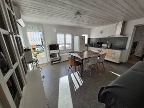Et moderne køkken med spiseplads, indbygget ovn og et stort vindue.