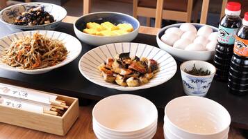 A dining table with various dishes, including bowls of food, a cup of tea, and condiments.