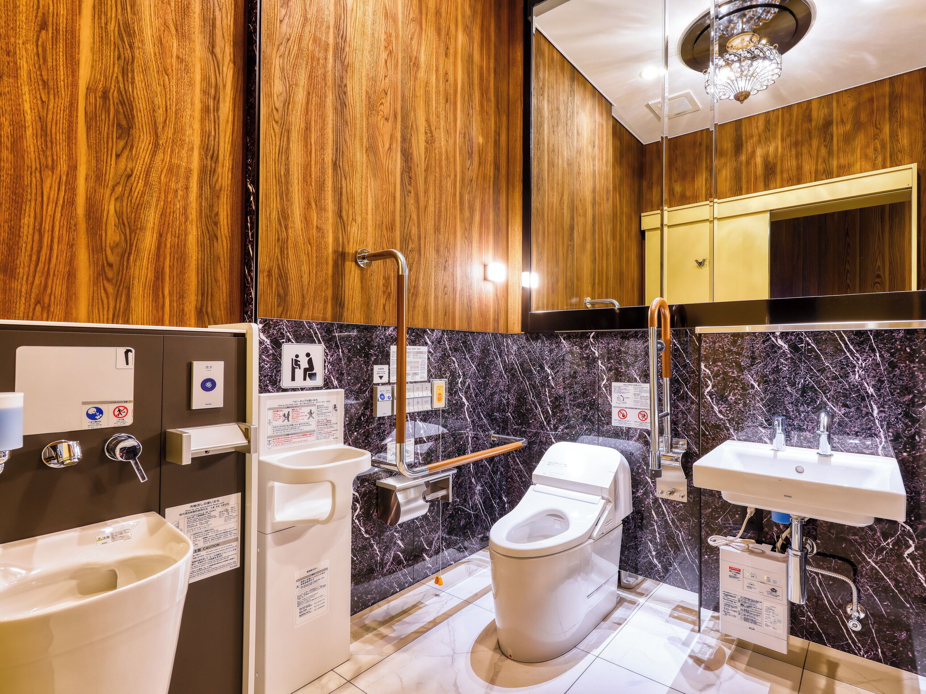 A modern bathroom with a toilet, sink, and hand dryer.