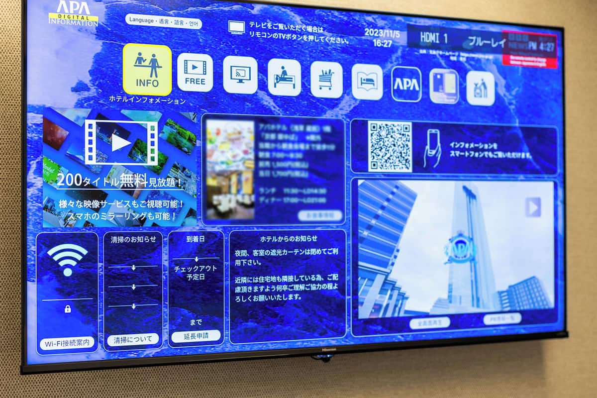 A digital display with various icons and text, including 'APA DIGITAL INFORMATION', 'FREE', and '200 タイトル無料見放題!'.
