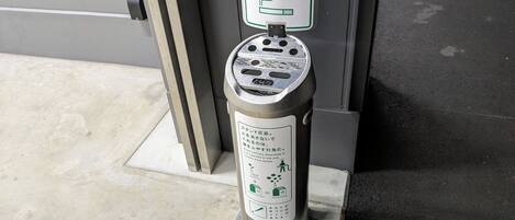 A public trash bin with a sign indicating it is for cigarette butts.