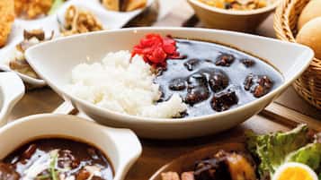 Variedad de platos que incluyen arroz, frijoles y un tazón de sopa, lo que sugiere una amplia selección de comidas.