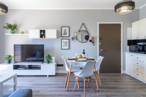 Una cocina moderna con microondas, cafetera y comedor con mesa dispuesta para cuatro.