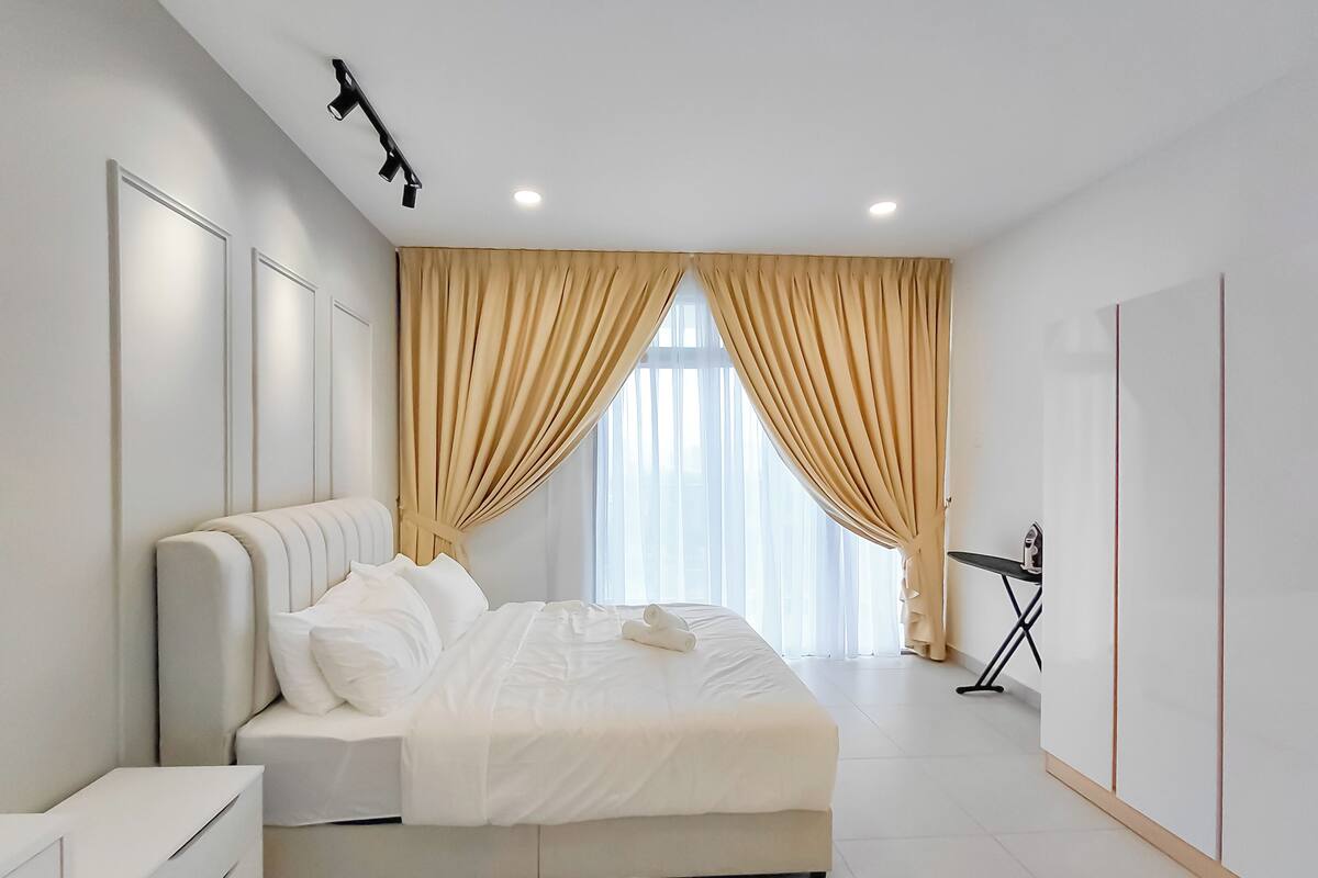 A modern bedroom with a bed, curtains, a nightstand, and a wardrobe.