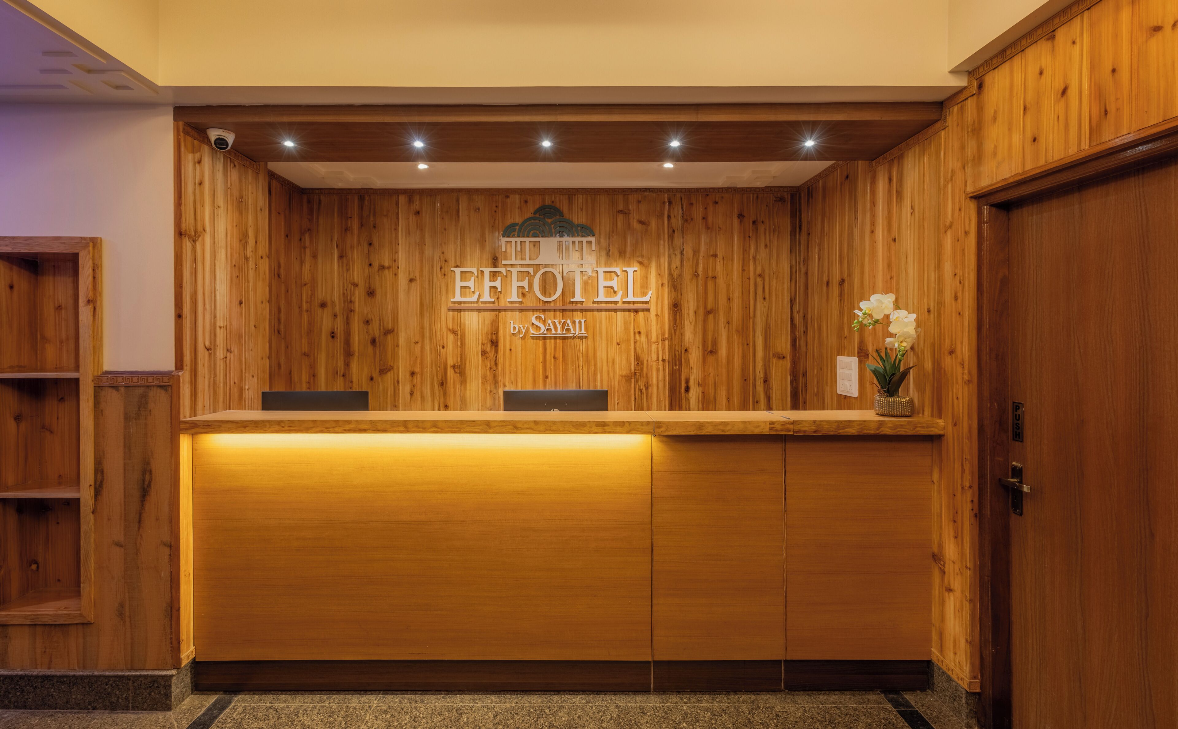 A wooden reception desk with a sign reading 'EFFOTEL by SAYAJI'.