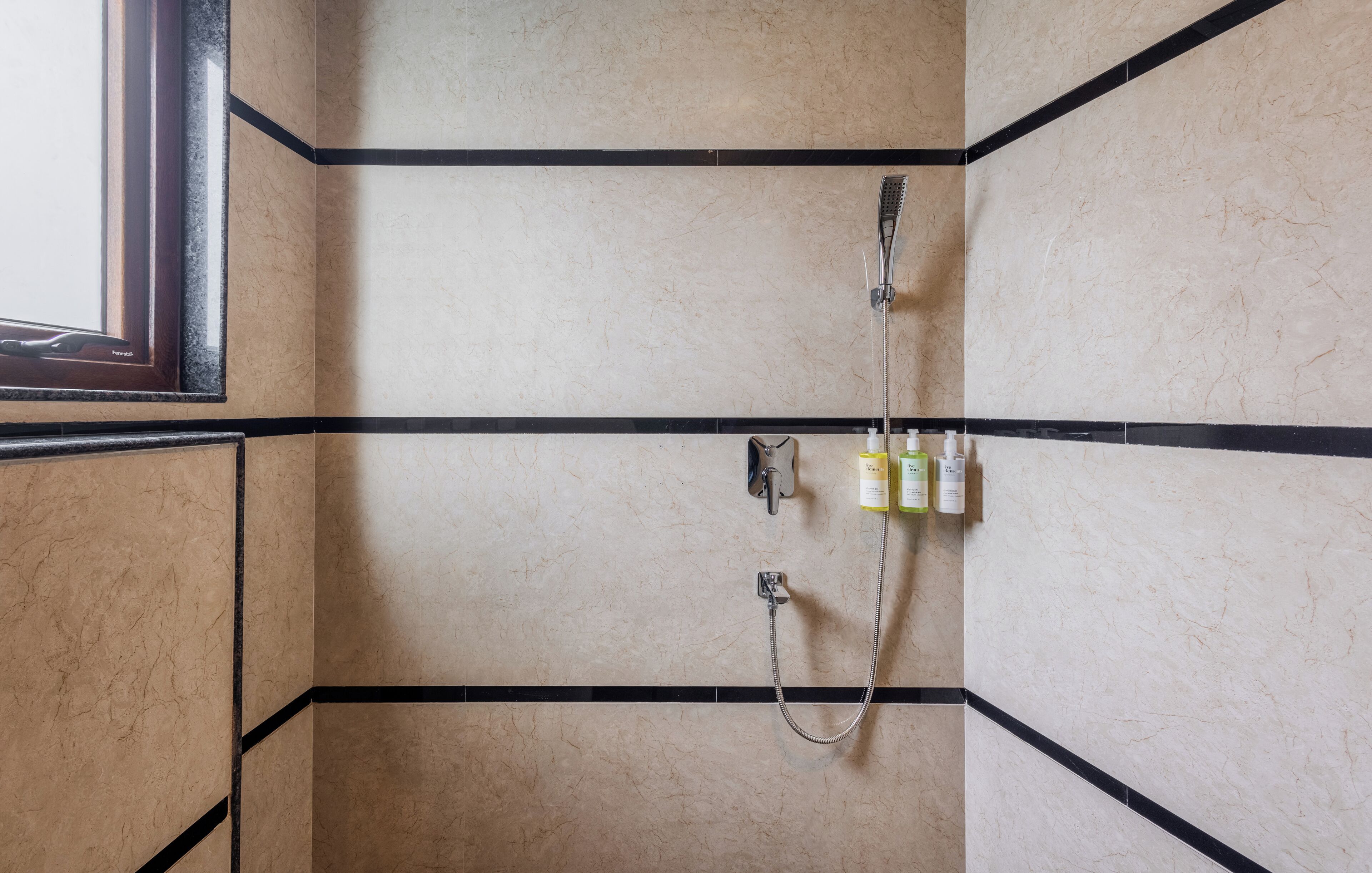 Ein Badezimmer mit Dusche, Spiegel und Fenster.