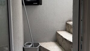 A narrow stairwell with a mop leaning against the wall and a bucket on the steps. - Cozy Guest Room Retreat in Scenic Kent Countryside (Kent)