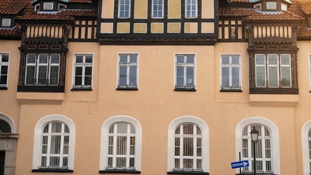 A traditional half-timbered building with multiple windows and a stone base.