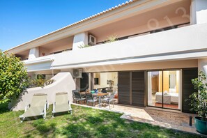 Ein modernes, zweistöckiges Haus mit Balkon, Essbereich und Schlafzimmer mit Schiebeglastür.