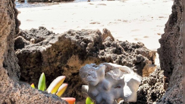 A beach scene viewed through a rocky archway with a clear view of the ocean and scattered rocks. - The Anunaka on Wadandi Boodja (Margaret River)