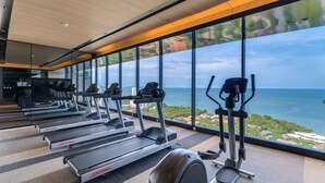 Una palestra con tapis roulant ed ellittiche, ampie finestre vista mare.