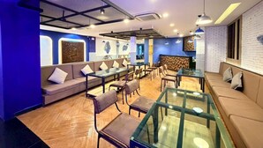 A modern interior with seating areas, tables, and a reception desk. - Serene Suite with Balcony and Pool View (Tambon Patong)