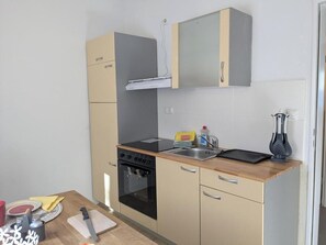 A compact kitchen with a stove, oven, and sink. - Holiday apartment Kuxborn in our guesthouse in the old town of Zell (Moselle) (Zell (Mosel))