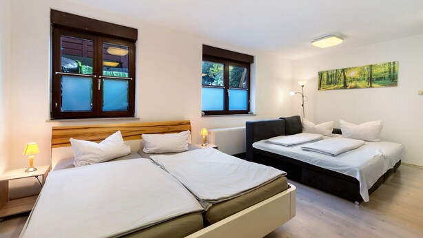 A hotel room with two beds, a window, a painting, and a lamp. - Apartment "Citywohnung Tettnang" with Wi-Fi (Tettnang)
