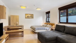 A bedroom with a bed, a sofa, a TV, a desk, and a painting on the wall. - Apartment "Citywohnung Tettnang" with Wi-Fi (Tettnang)