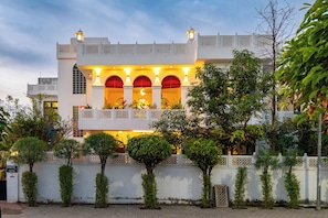 A traditional building with a white facade, arched windows, and a balcony with railings. - Bassi House 4-BHK Villa with Garden (Jaipur)