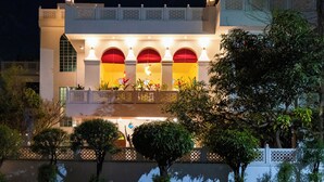 Ein Gebäude mit mehreren Bögen, einem Balkon und einer weißen Fassade.