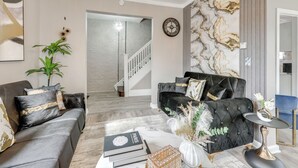 Ein modernes Wohnzimmer mit einer Couch, einem Couchtisch und einer Wanddekoration.