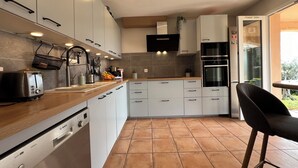 A modern kitchen with white cabinets, a Bosch dishwasher, a toaster, and a sink. - VILLA VUE MER LA FARDELOIE (La Ciotat)