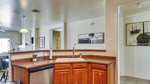 Une cuisine moderne avec des meubles en bois, un lave-vaisselle encastré et un grand îlot central doté d’un évier.