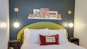 A bed with white and red pillows, a green headboard, and a wall with framed pictures and two wall-mounted lamps. - Unit 4: Central 1-BR, New Bath, 3 Mi to Dtwn (Spokane)