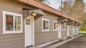 A row of single-story buildings with a uniform exterior design, featuring a series of windows and doors aligned along the facade. - Unit 4: Central 1-BR, New Bath, 3 Mi to Dtwn (Spokane)