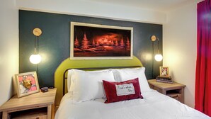 Una camera da letto ordinata con un letto, comodini, un quadro incorniciato e un lampadario a parete.