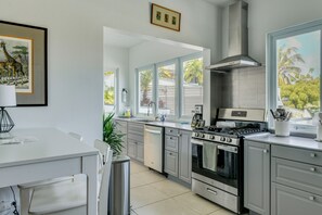 Eine moderne Küche mit Edelstahlgeräten, einem großen Fenster und einem gerahmten Bild an der Wand.