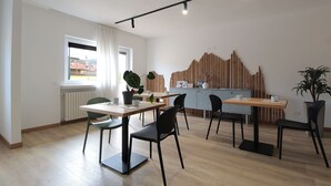 Un comedor moderno con una mesa de madera, sillas negras y una planta en maceta.