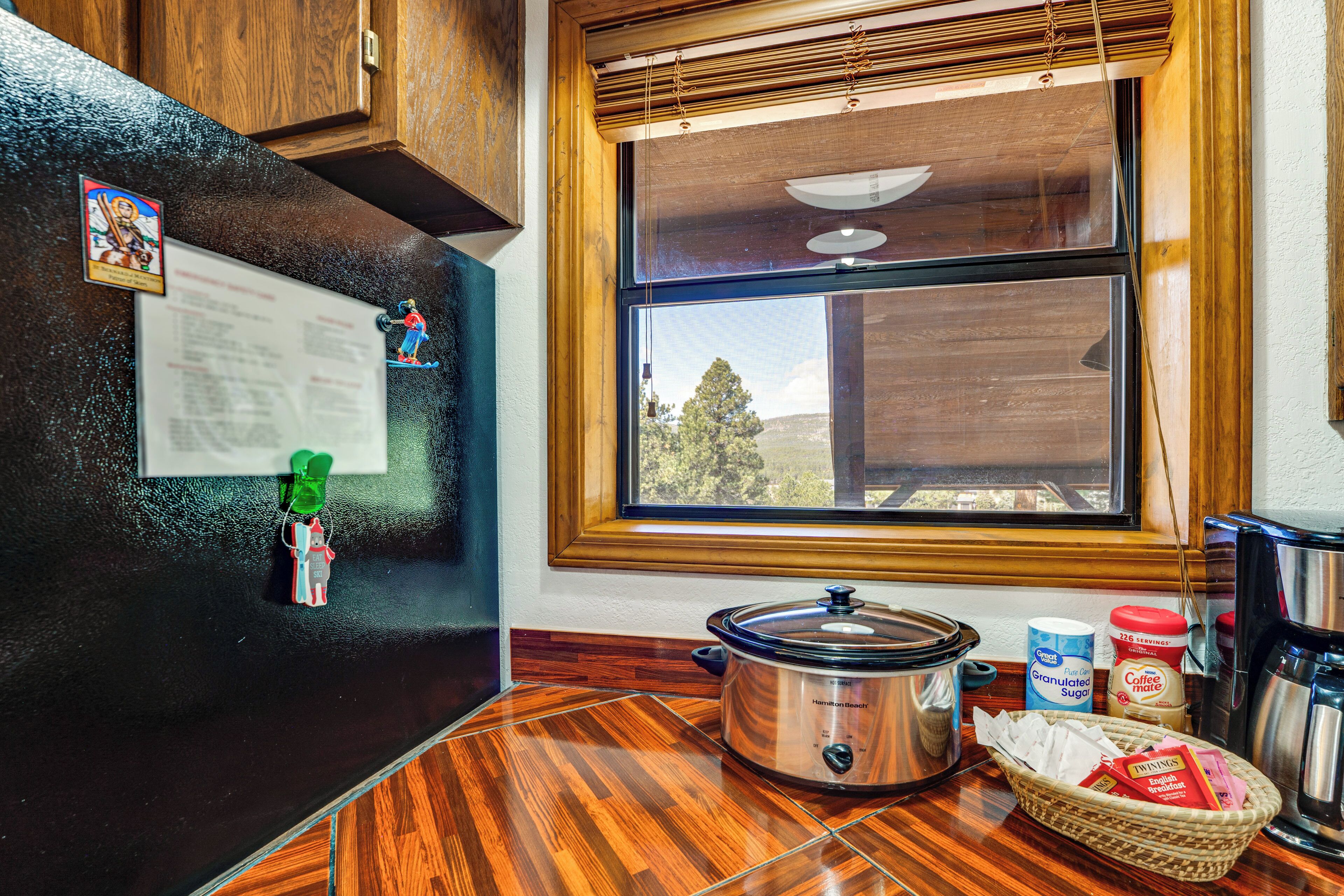 Una cocina con una olla de cocción lenta, una cafetera y una ventana con vistas.
