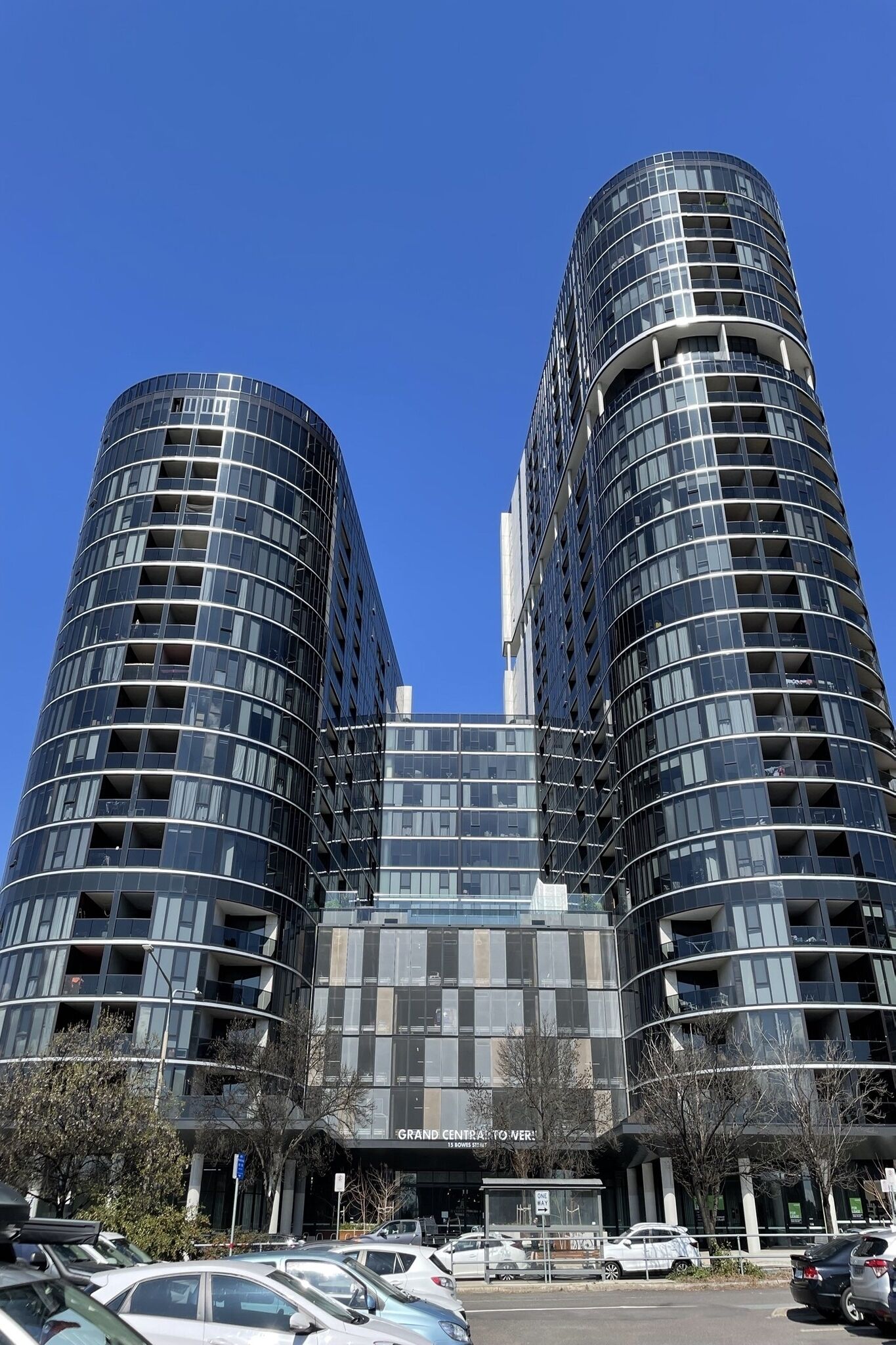 A modern building with a curved facade, multiple floors, and a sign reading 'Grand Central Tower'.