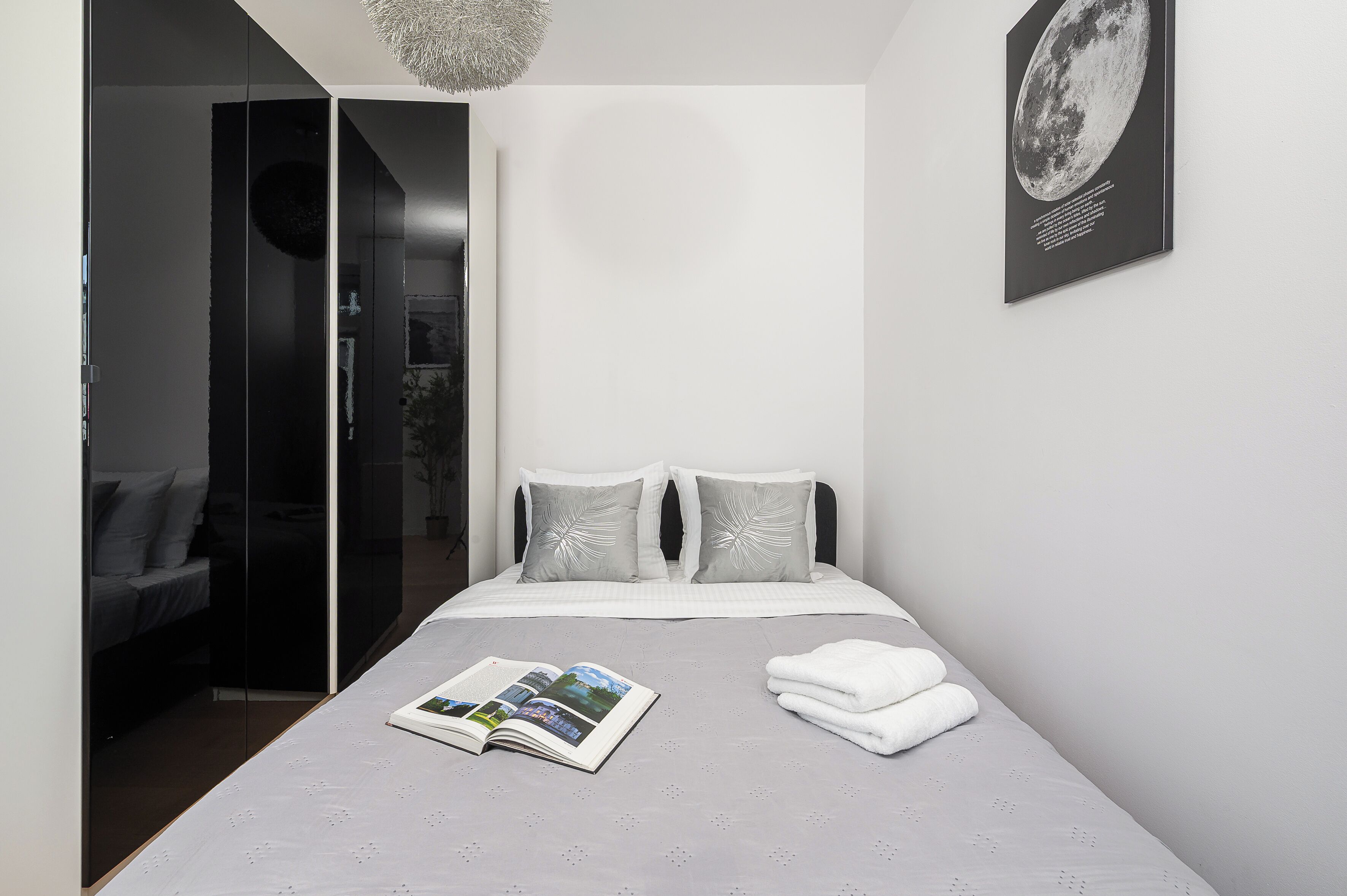 Een moderne slaapkamer met een bed, een tijdschrift en een handdoek op het bed.