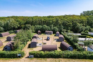 A campground with multiple dome-shaped cabins, a central gathering area, and a forested backdrop. - Holiday Home in Burgh-Haamstede (Burgh-Haamstede)
