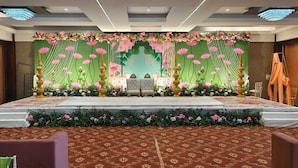 Un escenario con fondo floral, dos sillas y una mesa.