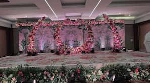 A stage with floral decorations and a patterned backdrop.