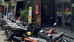 A McDonald's restaurant with a modern facade, a glass entrance, and a row of parked motorcycles outside. - Best Location | Home Cinema | Peaceful | Calmigo (Thành phố Hồ Chí Minh)