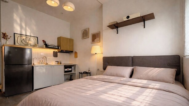 A bedroom with a bed, a kitchenette, a ceiling light fixture, and a wall-mounted shelf. - Best Location | Home Cinema | Peaceful | Calmigo (Thành phố Hồ Chí Minh)