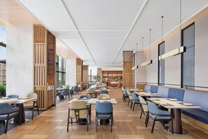 A spacious restaurant with high ceilings, modern furniture, and large windows. - Fairfield by Marriott Kunming Xishan (Kunming)