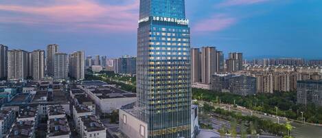 A high-rise hotel with a modern glass facade, surrounded by a dense urban environment.