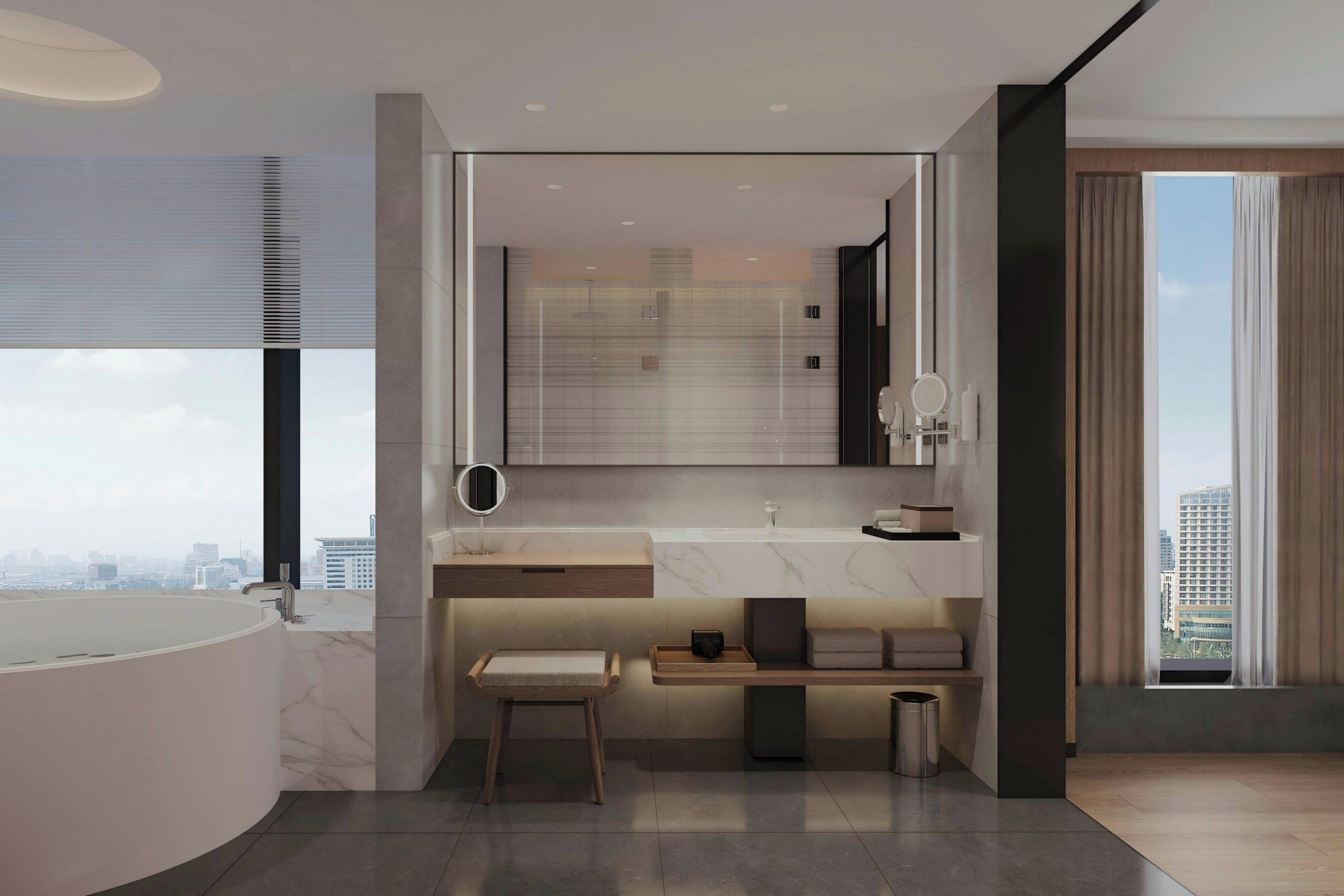 A modern bathroom with a large bathtub, a vanity with a mirror, and a bench.