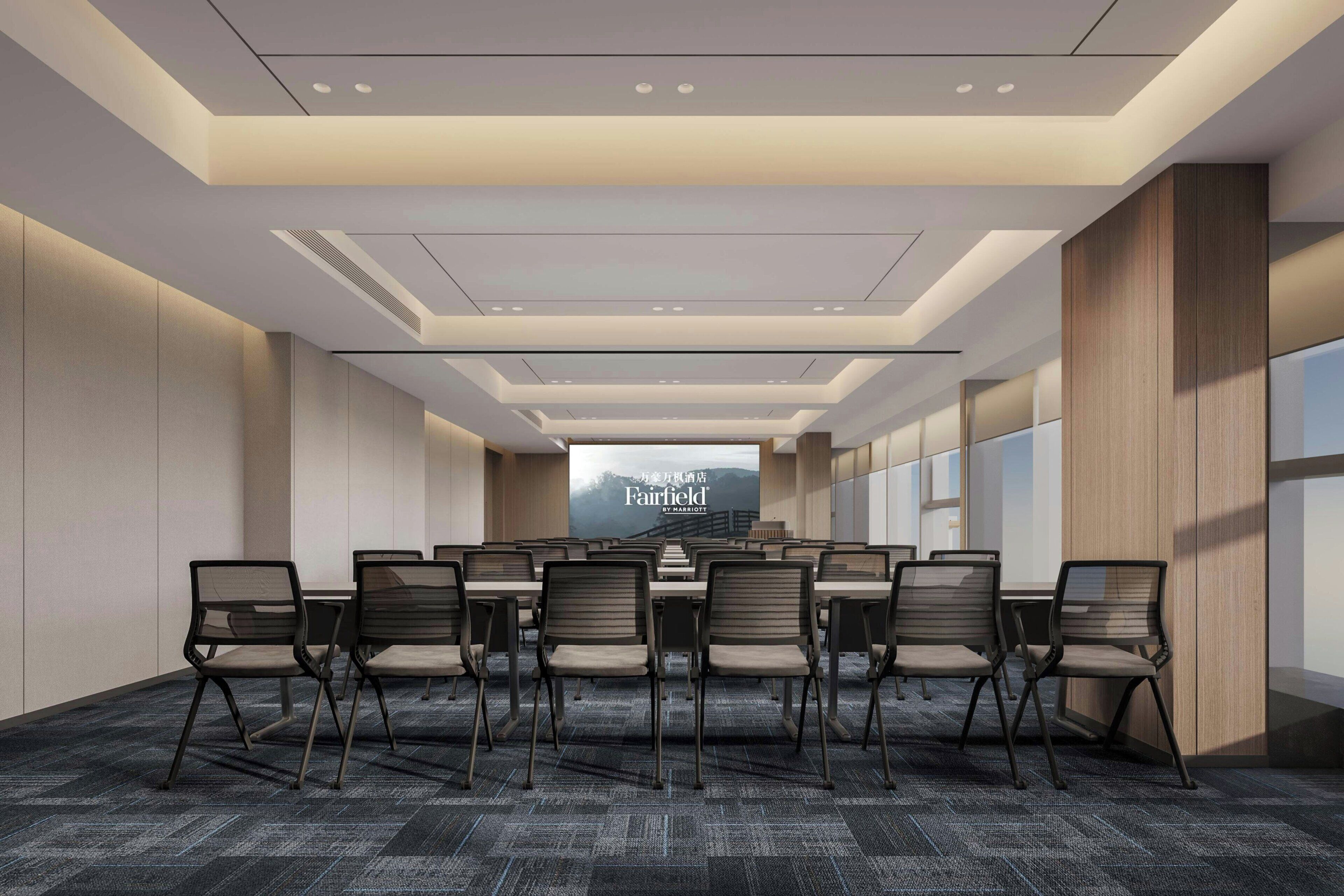 A conference room with a long table, chairs, and a large screen.