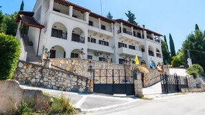 A multi-story building with balconies, a stone wall, and a gate. - Apartment 'Breathing  1' with Mountain View, Wi-Fi and Air Conditioning (Virós)