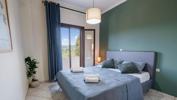 A bedroom with a bed, a potted plant, a view through a window, and a ceiling light. - Apartment 'Breathing  1' with Mountain View, Wi-Fi and Air Conditioning (Virós)