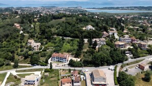 Vue aérienne d’un quartier résidentiel avec des maisons, des routes et une étendue d’eau au loin.