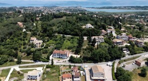 Vista aérea de una zona residencial con casas, caminos y un cuerpo de agua al fondo.
